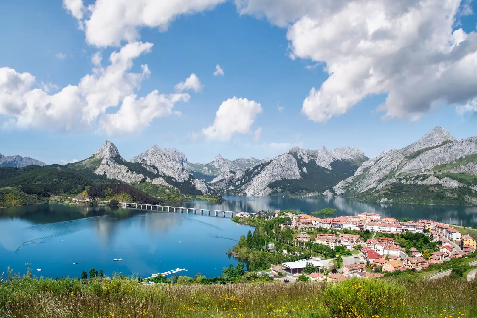 The village of Riaño on the shore of its reservoir, the road viaduct crossing the water, limestone peaks behind.